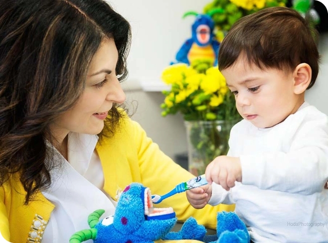 Forever Smiles Pediatric Dentistry | image of Dr. Abazari helping a child brush teeth